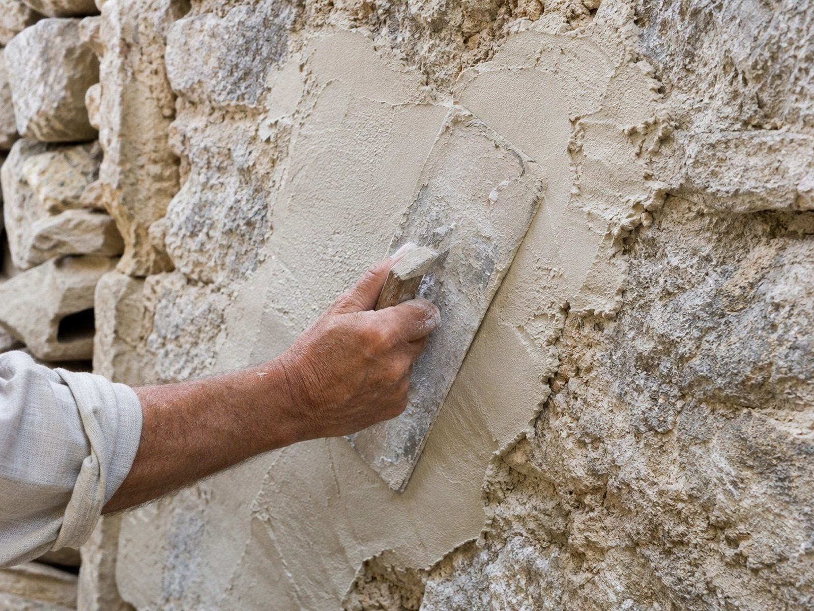 Application d’un enduit à la chaux sur un mur ancien