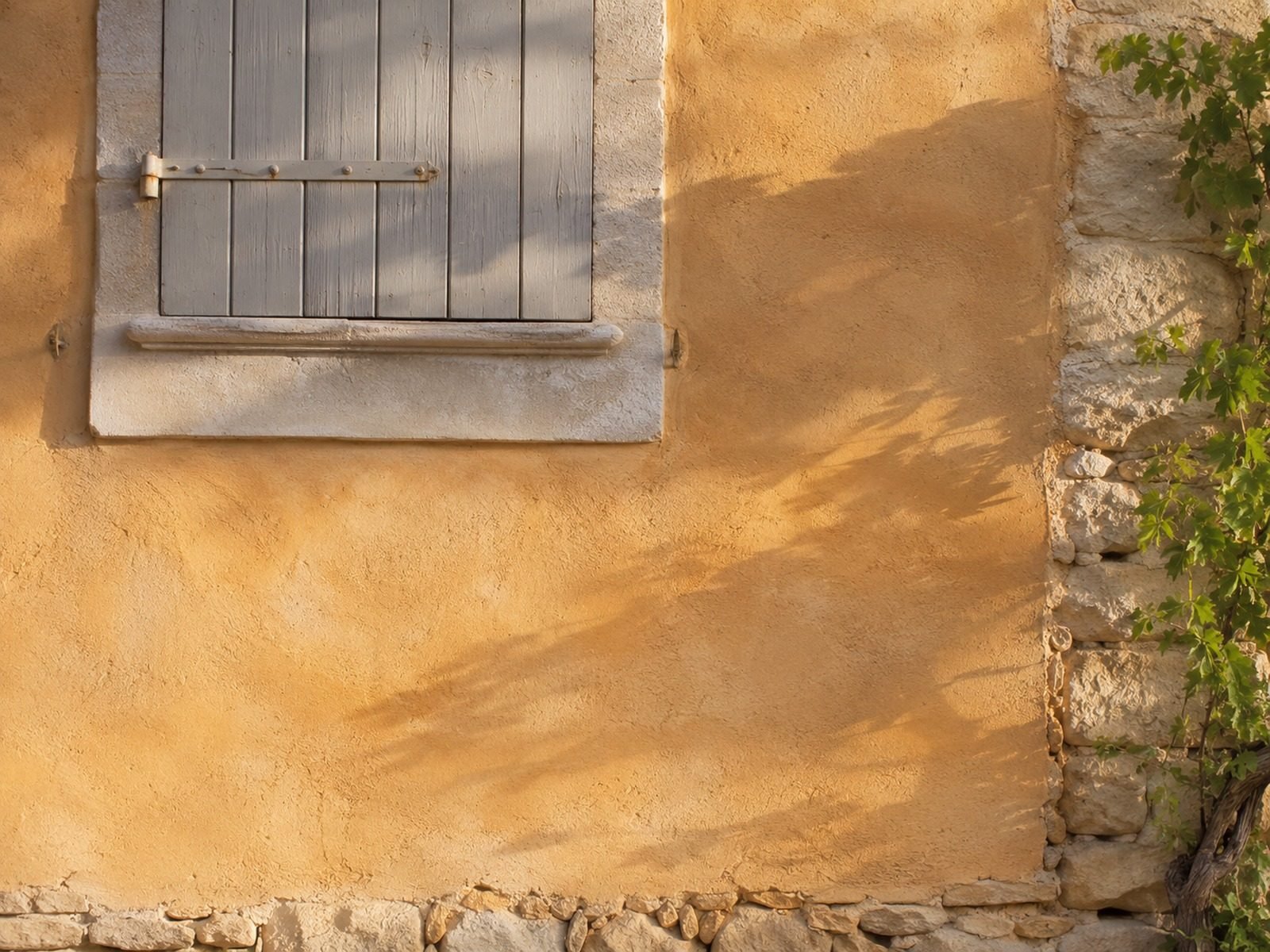 Badigeon à la chaux ocre sur une façade ancienne provençale